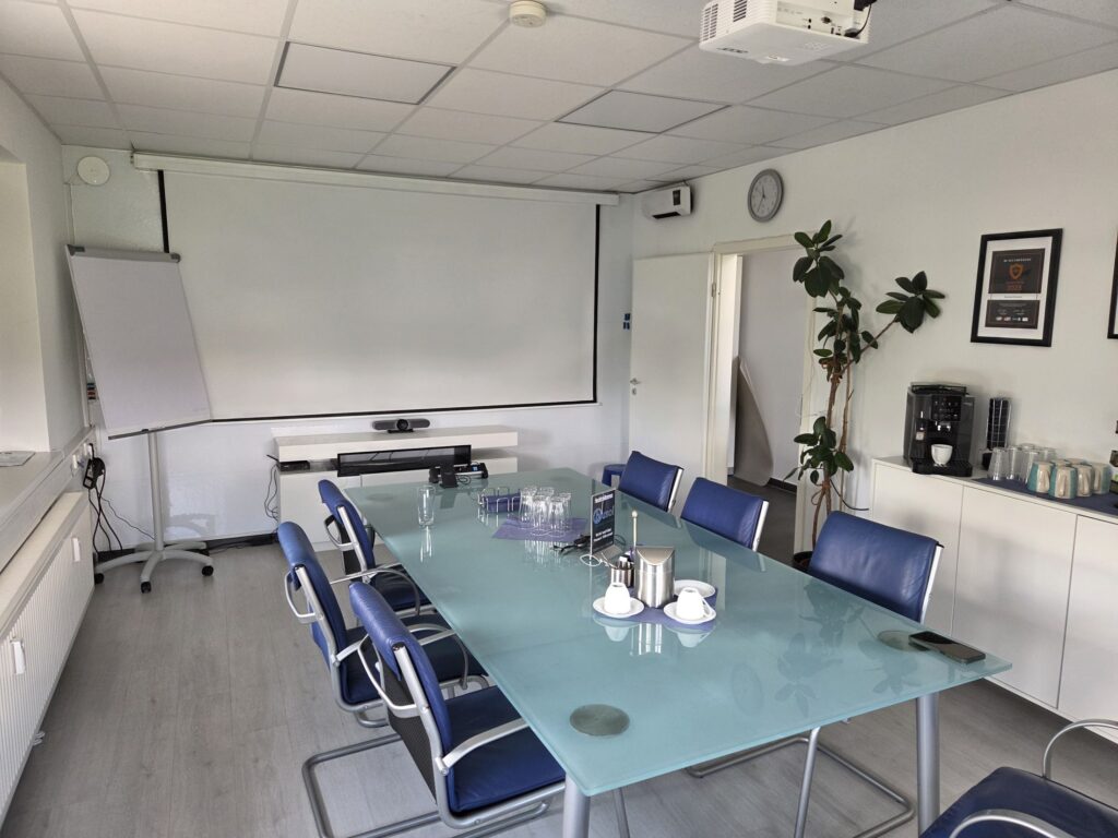 Konferenztisch mit Blick auf die Whiteboard-Wand